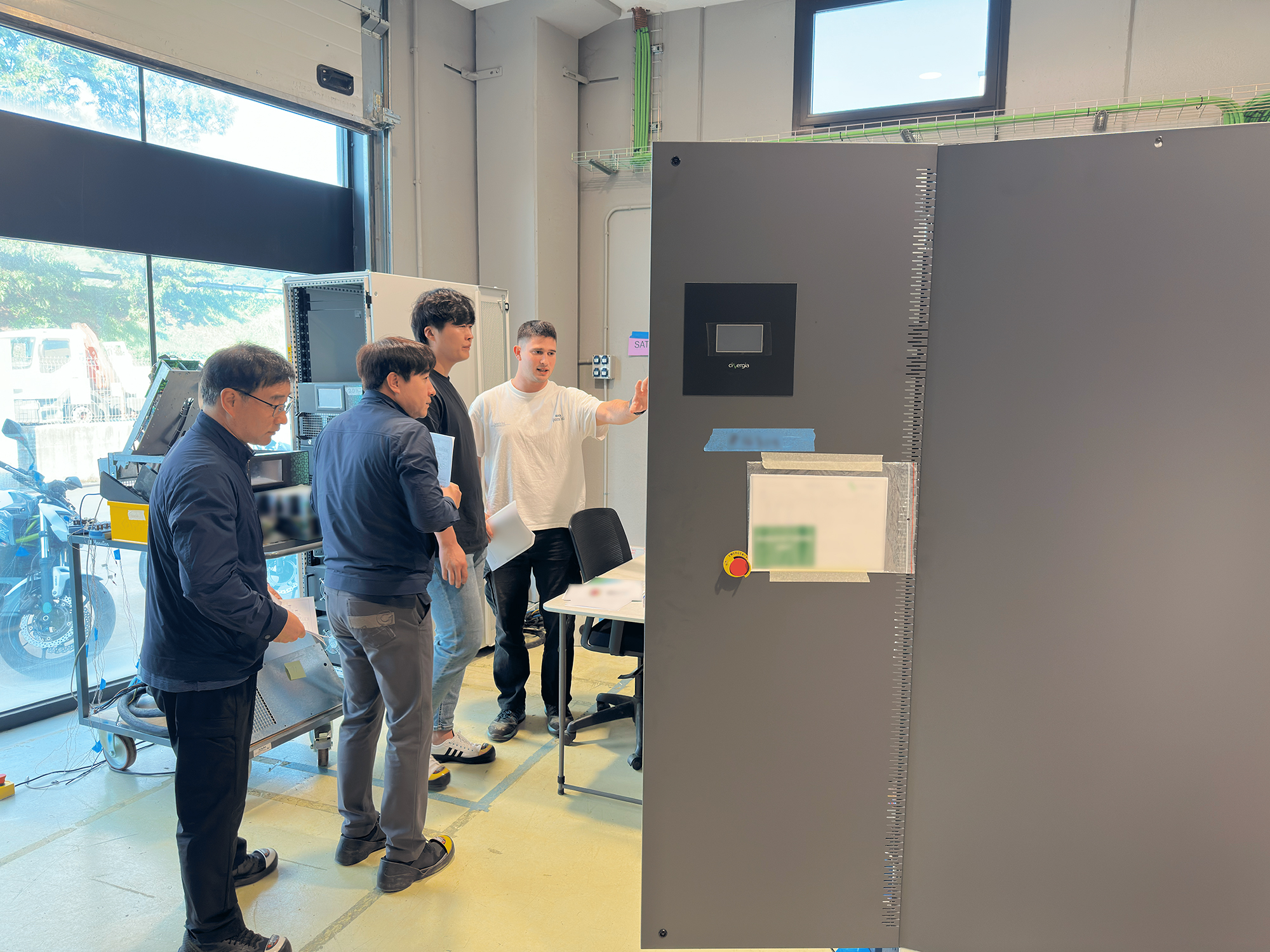 Cinergia's technical trainer guiding KMi engineers through the interface of a power electronics system.